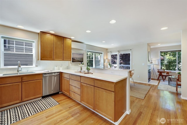 2643 NW 57th St Unit A, Seattle, WA 98107 - kitchen featuring stainless steel dishwasher, a peninsula, light wood-style floors, plenty of natural light, and recessed lighting