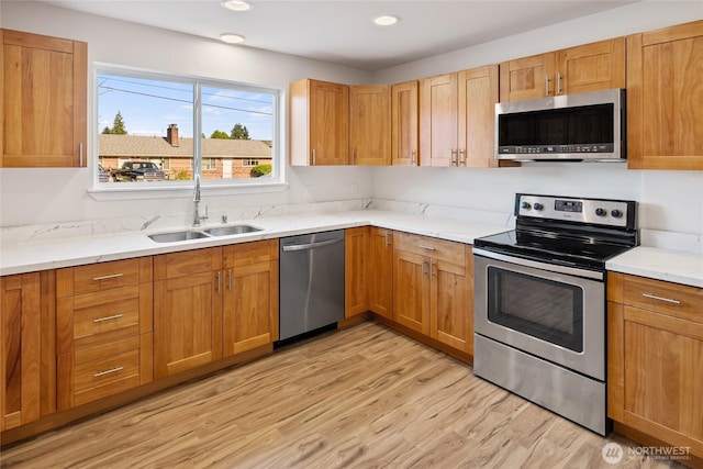 1003 9th St NW, Puyallup, WA 98371 - kitchen featuring stainless steel appliances, light wood finished floors, light stone countertops, recessed lighting, and brown cabinetry