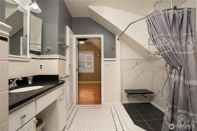 1016 N Madison St, Tacoma, WA 98406 - bathroom with tiled shower, tile patterned floors, tile walls, vanity, and vaulted ceiling