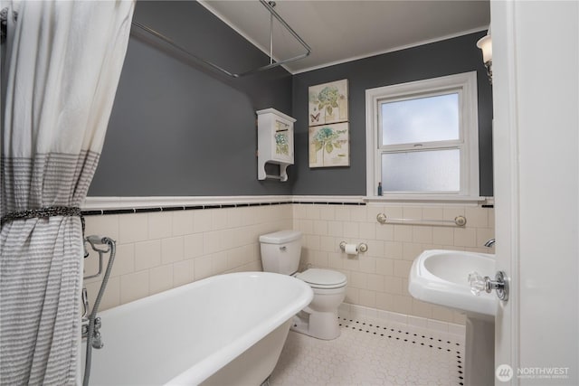 1016 N Madison St, Tacoma, WA 98406 - bathroom with a freestanding bath, a wainscoted wall, tile patterned floors, and tile walls