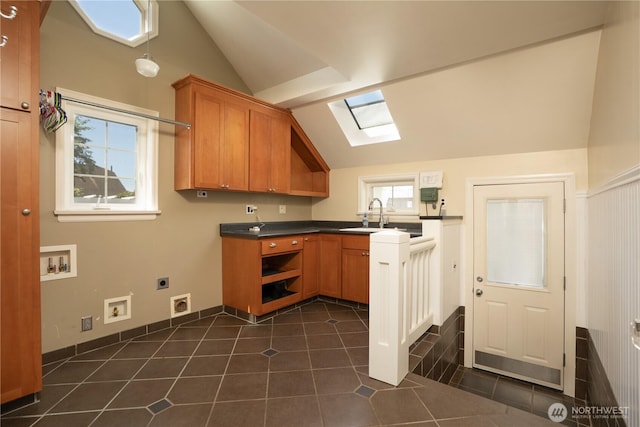 1016 N Madison St, Tacoma, WA 98406 - kitchen with lofted ceiling, a skylight, plenty of natural light, dark countertops, and brown cabinetry