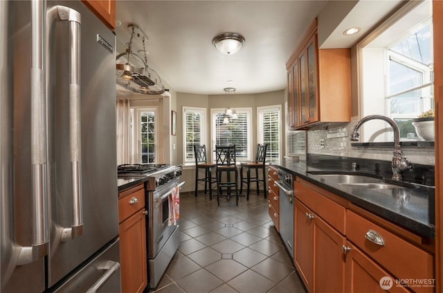 1016 N Madison St, Tacoma, WA 98406 - kitchen with premium appliances, brown cabinets, dark tile patterned floors, backsplash, and recessed lighting