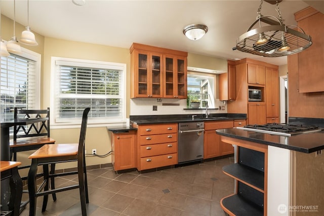 1016 N Madison St, Tacoma, WA 98406 - kitchen featuring appliances with stainless steel finishes, healthy amount of natural light, glass insert cabinets, and dark countertops