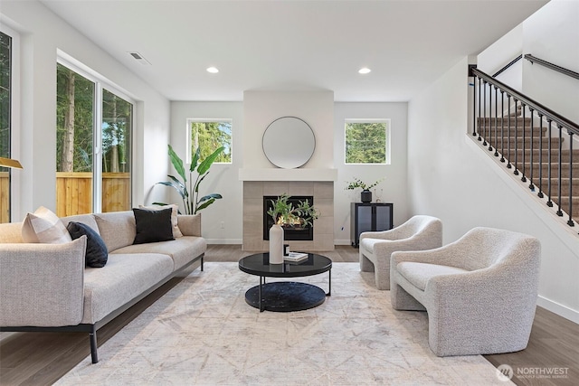 7150 90th Street Ct E, Puyallup, WA 98371 - living room featuring wood finished floors, baseboards, stairs, recessed lighting, and a tile fireplace