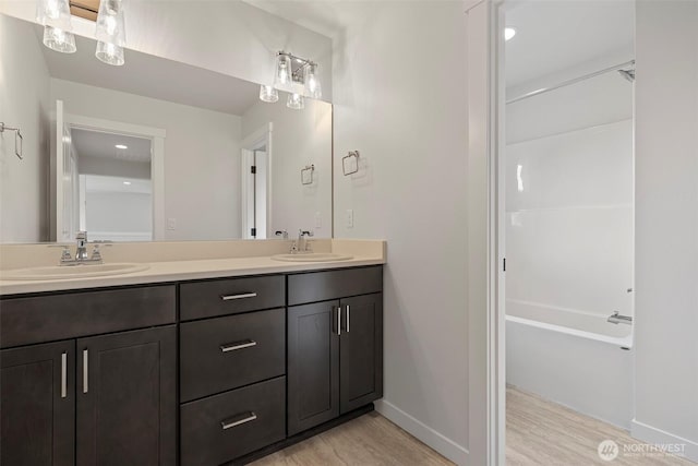 7150 90th Street Ct E, Puyallup, WA 98371 - bathroom featuring double vanity, wood finished floors, baseboards, and  shower combination