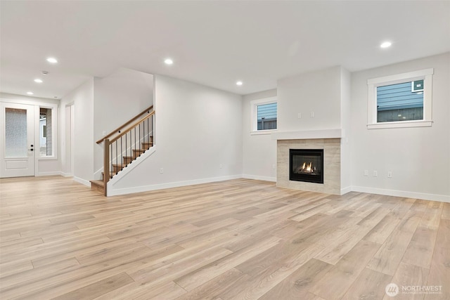 9036 71st Avenue Ct E, Puyallup, WA 98371 - unfurnished living room with light wood-style flooring, stairs, recessed lighting, baseboards, and a fireplace