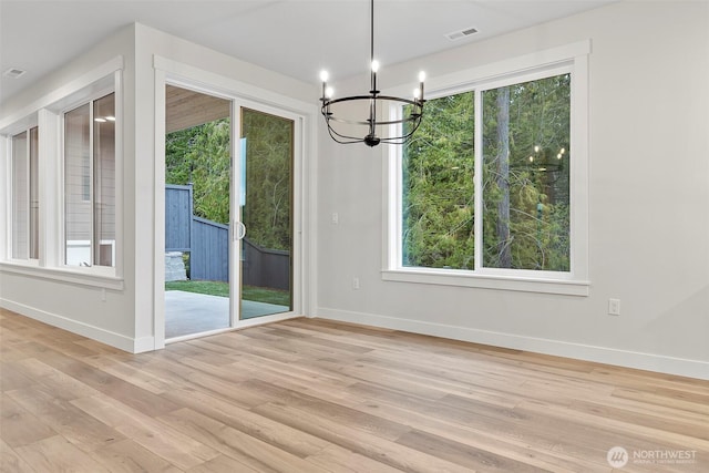 9036 71st Avenue Ct E, Puyallup, WA 98371 - unfurnished dining area featuring a chandelier, baseboards, light wood-style floors, and plenty of natural light