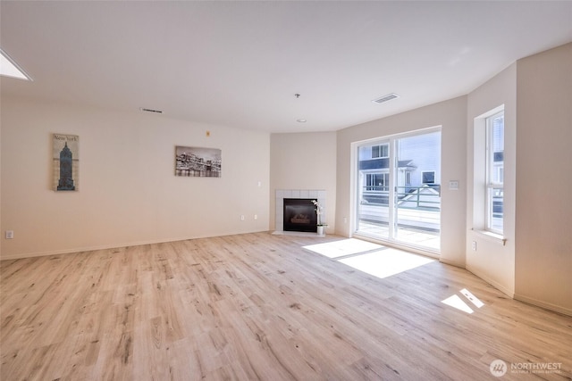 16219 Northup Way Unit C-202, Bellevue, WA 98008 - unfurnished living room featuring light wood-style floors and a tiled fireplace