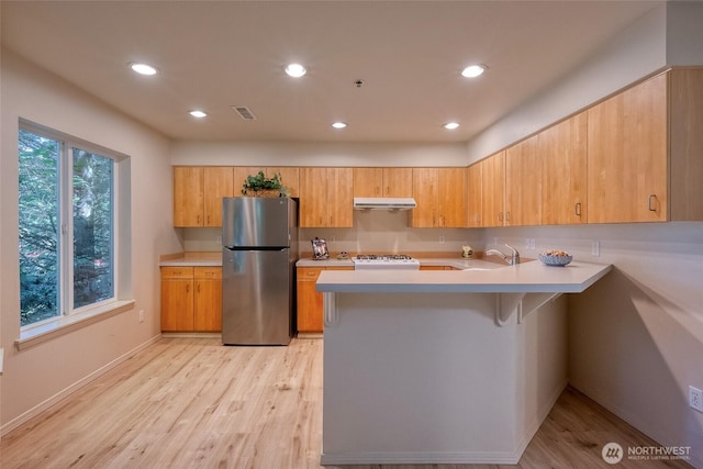 16219 Northup Way Unit C-202, Bellevue, WA 98008 - kitchen featuring freestanding refrigerator, under cabinet range hood, a peninsula, light countertops, and recessed lighting