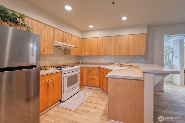 16219 Northup Way Unit C-202, Bellevue, WA 98008 - kitchen featuring freestanding refrigerator, white gas stove, a peninsula, under cabinet range hood, and light wood finished floors