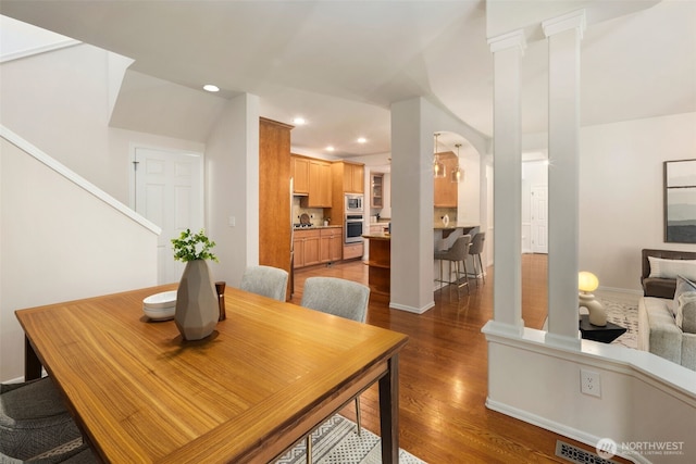 11734 167th Ct NE, Redmond, WA 98052 - dining area with dark wood-style floors, recessed lighting, arched walkways, decorative columns, and stairs