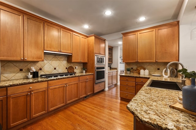 11734 167th Ct NE, Redmond, WA 98052 - kitchen featuring appliances with stainless steel finishes, light wood-style flooring, recessed lighting, brown cabinetry, and exhaust hood