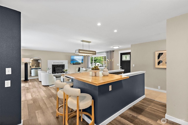 2422 179th Ave E, Lake Tapps, WA 98391 - kitchen with butcher block counters, wood finished floors, a kitchen breakfast bar, a kitchen island, and recessed lighting