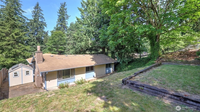 22230 100th Ave SE, Kent, WA 98031 - rear view of house featuring a chimney, a storage unit, and roof with shingles