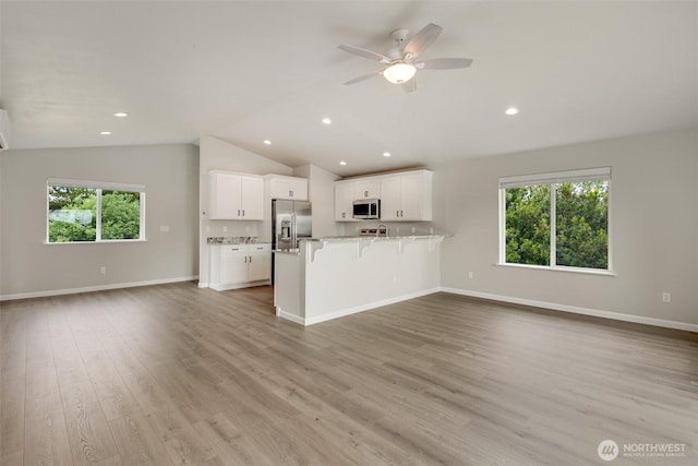 356 N Wynoochee Dr SW, Ocean Shores, WA 98569 - unfurnished living room featuring lofted ceiling, healthy amount of natural light, ceiling fan, light wood-style flooring, and recessed lighting