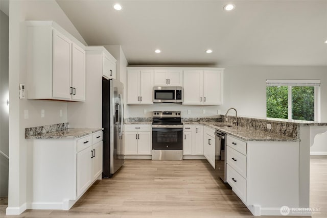 356 N Wynoochee Dr SW, Ocean Shores, WA 98569 - kitchen featuring stainless steel appliances, a peninsula, light wood-style flooring, white cabinets, and recessed lighting