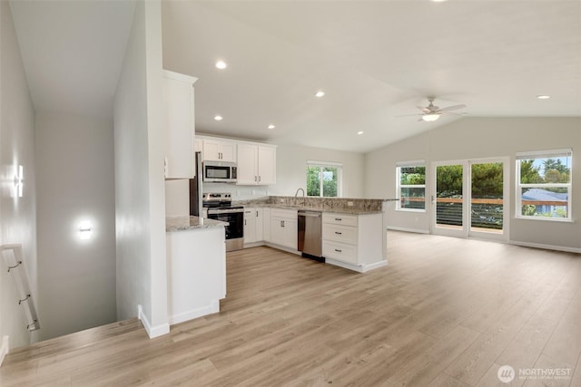 356 N Wynoochee Dr SW, Ocean Shores, WA 98569 - kitchen with stainless steel appliances, a ceiling fan, vaulted ceiling, light wood-type flooring, and white cabinets