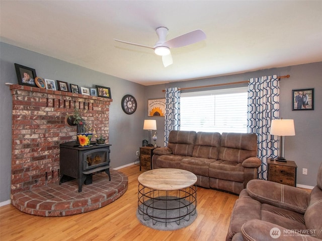 1011 E 5th St, Port Angeles, WA 98362 - living room featuring wood finished floors, a ceiling fan, baseboards, and a wood stove