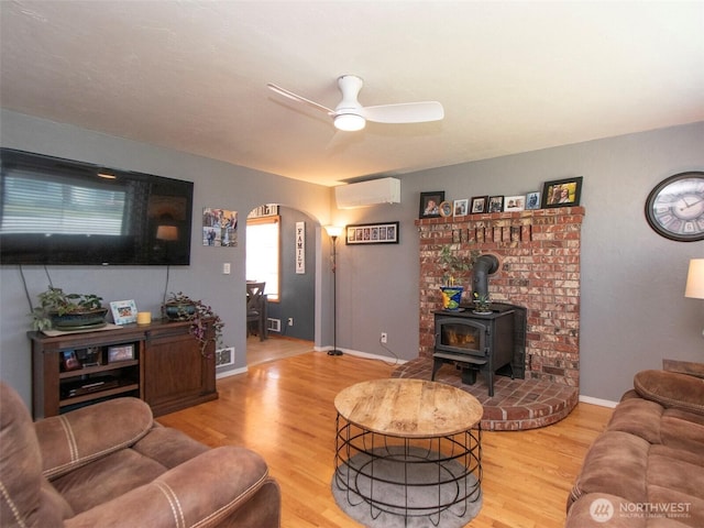 1011 E 5th St, Port Angeles, WA 98362 - living area with arched walkways, a wall mounted AC, wood finished floors, ceiling fan, and baseboards