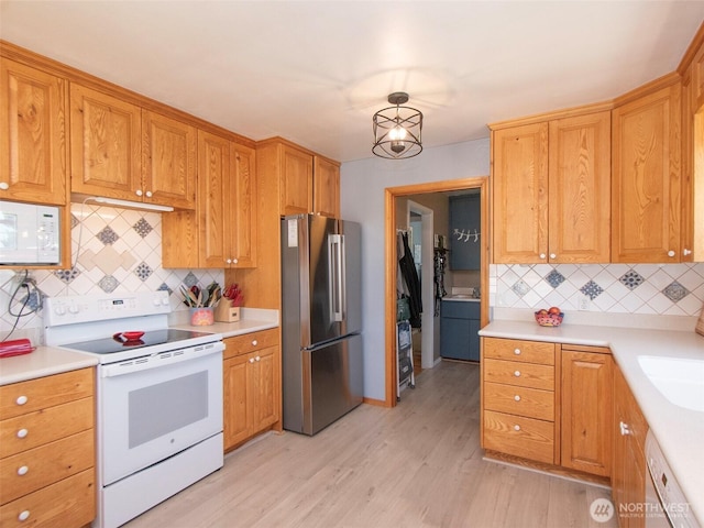 1011 E 5th St, Port Angeles, WA 98362 - kitchen with white appliances, decorative backsplash, light wood-type flooring, and light countertops