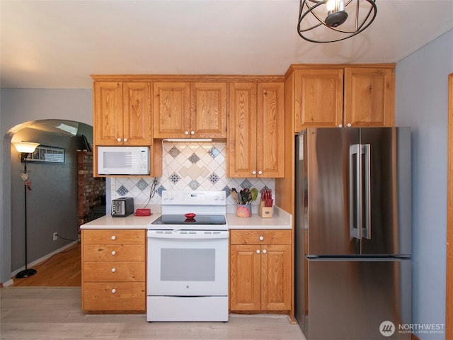 1011 E 5th St, Port Angeles, WA 98362 - kitchen with white appliances, arched walkways, tasteful backsplash, and light countertops