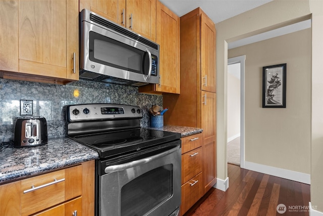 8503 Bowdoin Way Unit 203, Edmonds, WA 98026 - kitchen featuring appliances with stainless steel finishes, dark wood-style floors, dark stone counters, backsplash, and baseboards