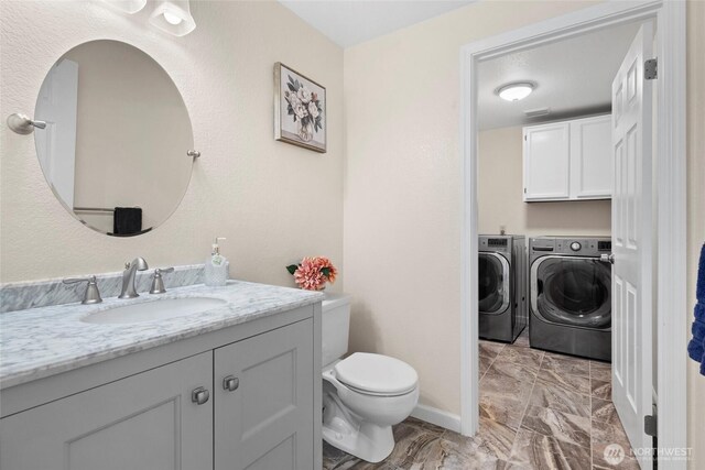 5610 S 296th Ct, Auburn, WA 98001 - bathroom featuring washing machine and clothes dryer, marble finish floors, and vanity