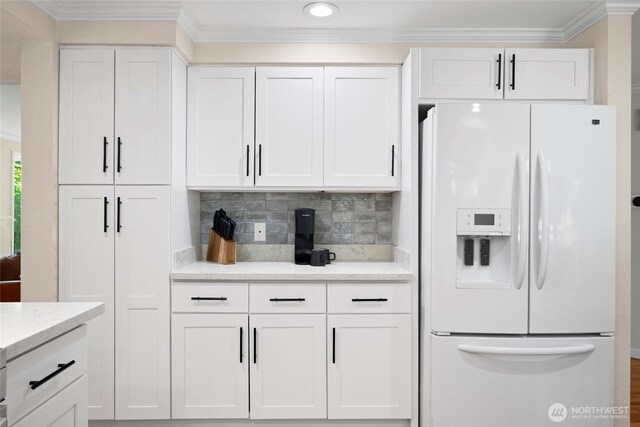 5610 S 296th Ct, Auburn, WA 98001 - kitchen featuring white fridge with ice dispenser, ornamental molding, white cabinetry, backsplash, and light stone countertops