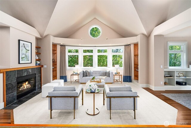 13730 Main St, Bellevue, WA 98005 - living room featuring vaulted ceiling, a tile fireplace, plenty of natural light, and wood finished floors