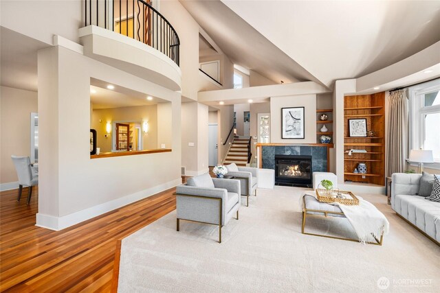 13730 Main St, Bellevue, WA 98005 - living area with wood finished floors, stairs, a fireplace, high vaulted ceiling, and built in features