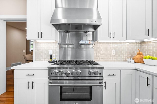 13730 Main St, Bellevue, WA 98005 - kitchen featuring high end range, light countertops, wood finished floors, and decorative backsplash