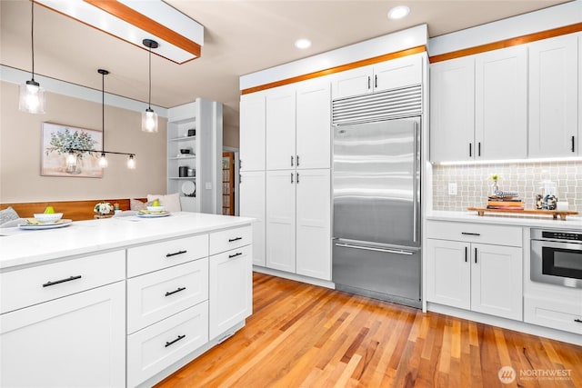 13730 Main St, Bellevue, WA 98005 - kitchen featuring stainless steel appliances, white cabinetry, light countertops, decorative light fixtures, and recessed lighting