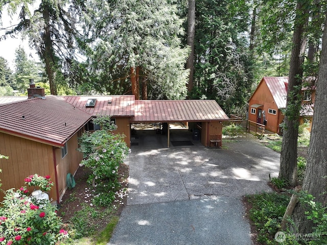 808 Woodsong Ln, Langley, WA 98260 - view of front of home featuring driveway, an attached carport, a metal roof, and a chimney