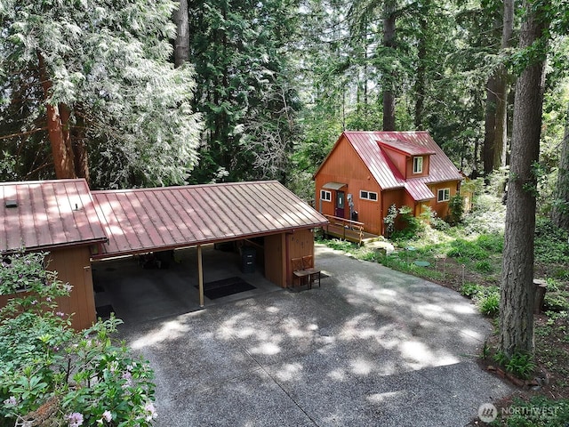 808 Woodsong Ln, Langley, WA 98260 - garage with driveway, a carport, and a view of trees