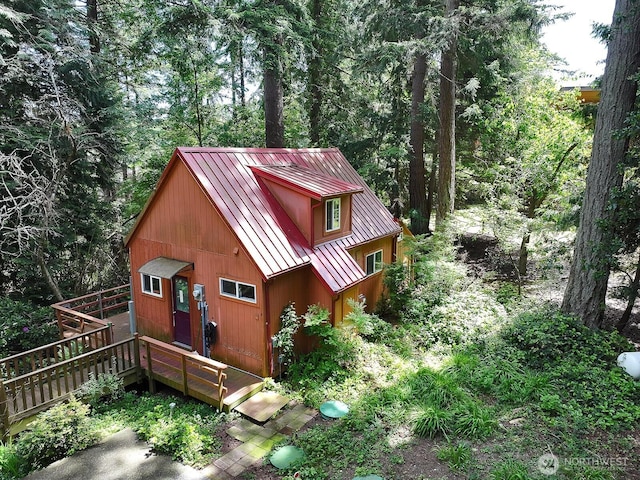 808 Woodsong Ln, Langley, WA 98260 - view of property exterior with a standing seam roof, a metal roof, a wooden deck, and a wooded view