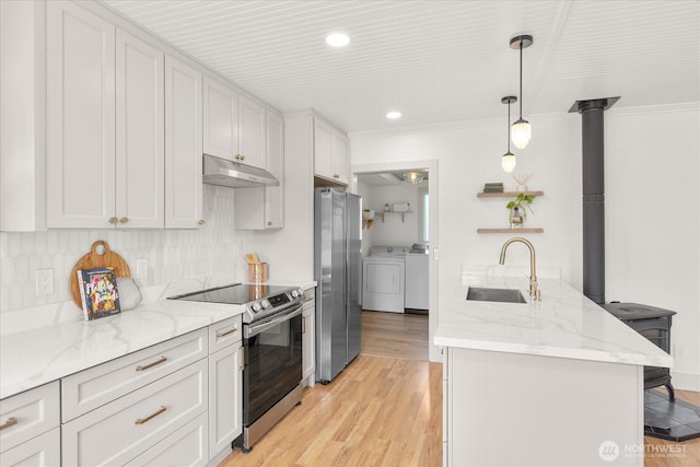 1115Avenue A, Snohomish, WA 98290 - kitchen with appliances with stainless steel finishes, independent washer and dryer, under cabinet range hood, ornamental molding, and a peninsula