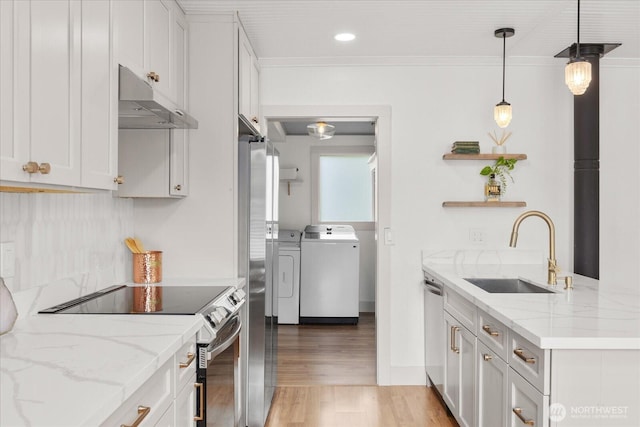1115Avenue A, Snohomish, WA 98290 - kitchen with under cabinet range hood, stainless steel appliances, washer and clothes dryer, light wood-style floors, and white cabinetry