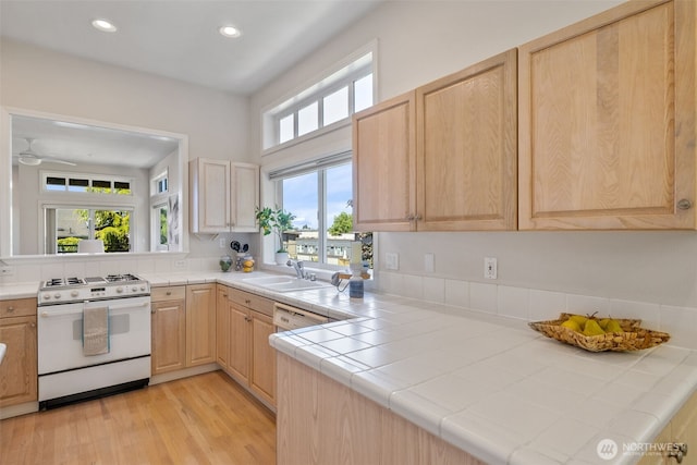 327 2nd Ave S, Kirkland, WA 98033 - kitchen with white gas stove, tile countertops, light brown cabinetry, light wood finished floors, and recessed lighting
