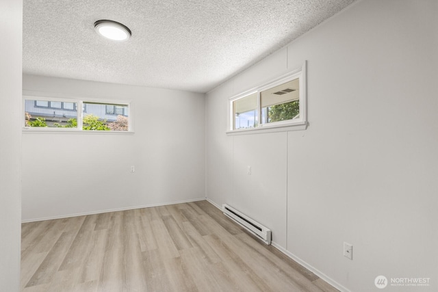 15330 40th Ave W Unit A & B, Lynnwood, WA 98087 - empty room featuring a baseboard heating unit, a textured ceiling, light wood-style floors, and baseboards