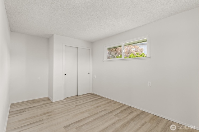 15330 40th Ave W Unit A & B, Lynnwood, WA 98087 - unfurnished bedroom featuring a textured ceiling, light wood-style floors, a closet, and baseboards