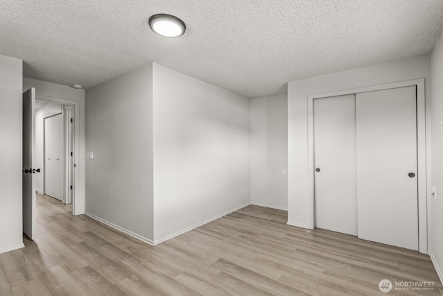15330 40th Ave W Unit A & B, Lynnwood, WA 98087 - unfurnished bedroom featuring light wood finished floors, a textured ceiling, a closet, and baseboards