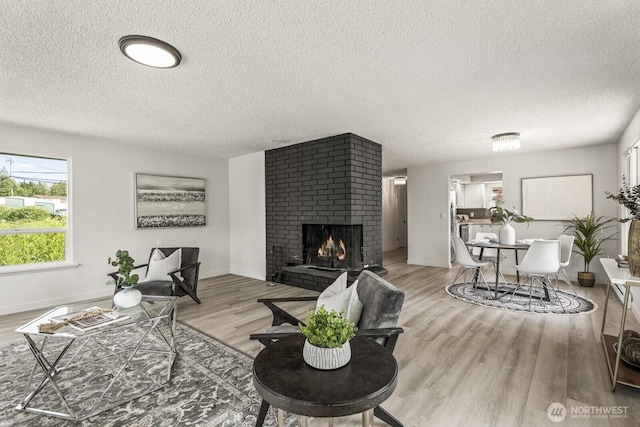 15330 40th Ave W Unit A & B, Lynnwood, WA 98087 - living area featuring a textured ceiling, light wood-type flooring, a fireplace, and baseboards