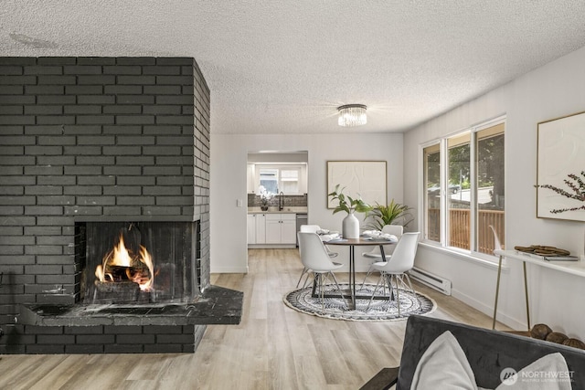 15330 40th Ave W Unit A & B, Lynnwood, WA 98087 - dining area featuring light wood-style floors, plenty of natural light, baseboard heating, a textured ceiling, and a fireplace