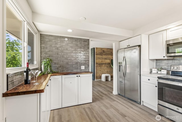 15330 40th Ave W Unit A & B, Lynnwood, WA 98087 - kitchen featuring appliances with stainless steel finishes, butcher block counters, tasteful backsplash, white cabinetry, and light wood finished floors