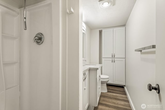 15330 40th Ave W Unit A & B, Lynnwood, WA 98087 - full bathroom featuring wood finished floors, vanity, a textured ceiling, a shower, and baseboards