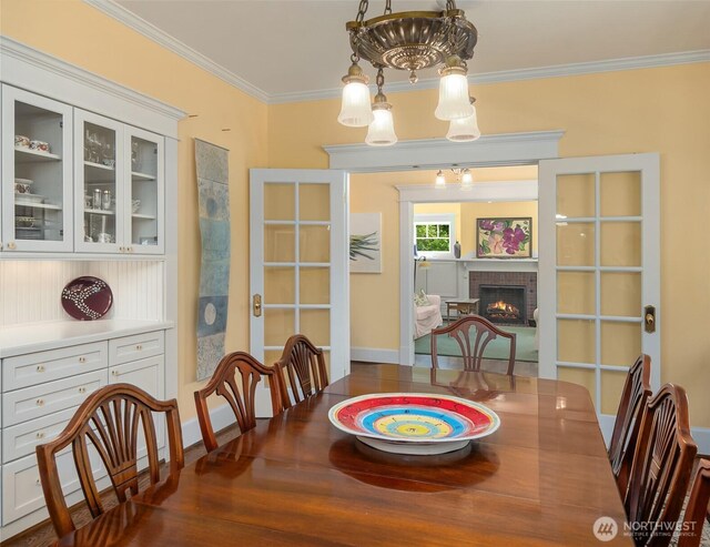 19840 Vashon Hwy SW, Vashon, WA 98070 - dining room with crown molding, a brick fireplace, and wood finished floors