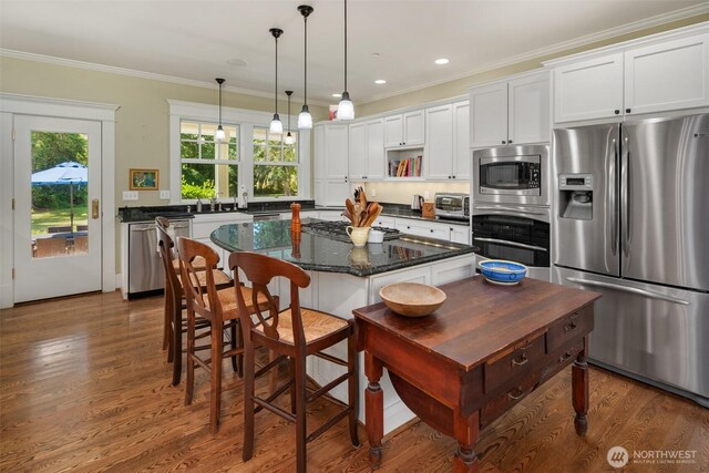 19840 Vashon Hwy SW, Vashon, WA 98070 - kitchen featuring stainless steel appliances, crown molding, white cabinets, a center island, and hanging light fixtures