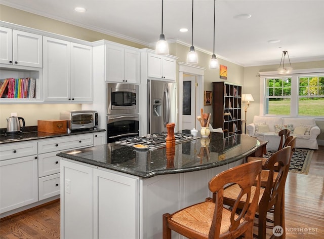 19840 Vashon Hwy SW, Vashon, WA 98070 - kitchen featuring stainless steel appliances, white cabinetry, wood finished floors, a breakfast bar, and crown molding