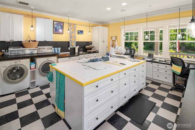 19840 Vashon Hwy SW, Vashon, WA 98070 - kitchen featuring washing machine and dryer, dark flooring, recessed lighting, white cabinets, and ornamental molding