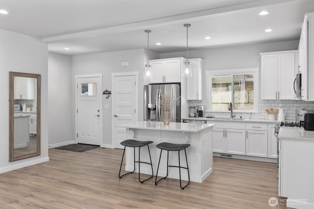 18207 Majestic Ridge Ln, Mount Vernon, WA 98274 - kitchen with appliances with stainless steel finishes, tasteful backsplash, recessed lighting, a breakfast bar area, and light wood-style flooring